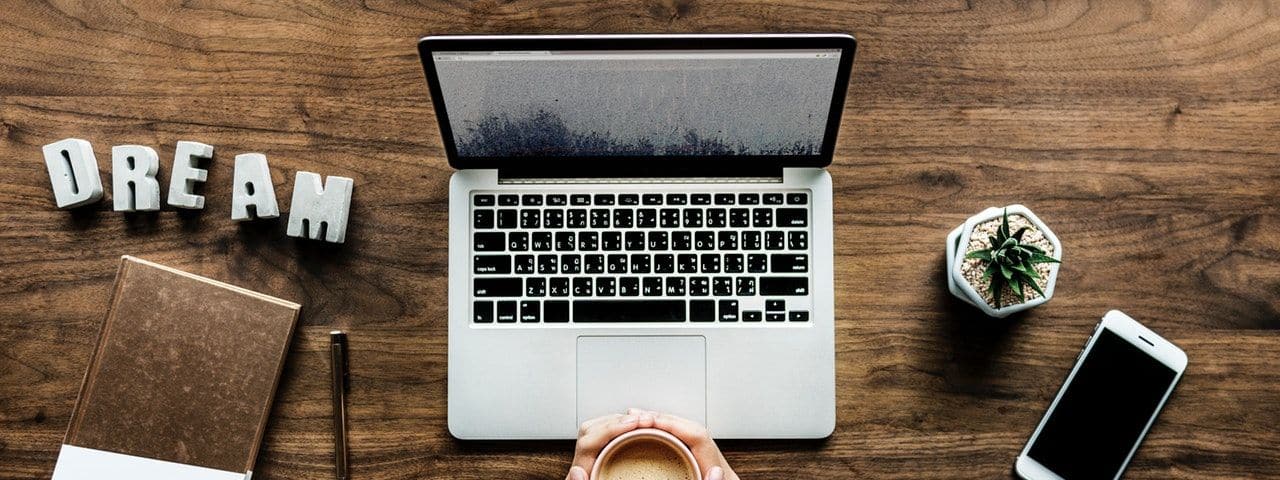 9 Legit Online Jobs with No Experience - Laptop, coffee, phone and the word dream on a table