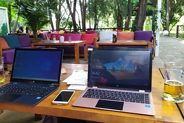 What is a Digital Nomad? - Two laptops, mobile phone and beers on a table in an outdoor restaurant